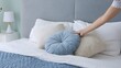 © Traveler0205 - Woman arranges pillows on bed creating a cozy retreat. With each pillow placed, bed transforms into sanctuary of comfort The soft embrace of pillows invites relaxation promising peaceful night's sleep