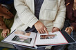 Close up of senior woman with two children looking at pictures in photo album and sharing family history copy space