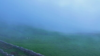 Wall Mural - Fog between meadows and pasiegas cabins around Portillo de la Sía in the area around the town of La Gándara in the Soba Valley. Pasiegos Valleys. Cantabria. Spain. Europe