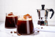 Cold Brew Coffee Espresso Carajillo Cocktail with frozen espresso ice cubes, strong black coffee, liqueur and Vodka, on white kitchen table background copy space