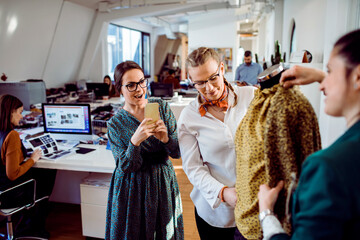 Wall Mural - Fashion designers reviewing a clothing sample in a modern studio workspace
