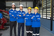 Group of robotic engineers wear helmets safety standing and arms crossed at factory workshop. Technician professional team robot arm welding machine.