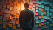 man looking at a wall full of sticky notes