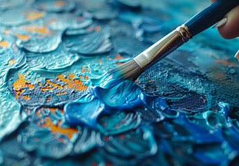 A person is painting a blue and orange ocean scene with a brush. The brush is being used to create a textured effect on the canvas.