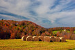 farmer's fields with bales of hay and a view of the magnificent colorful autumn mountains. Vermont. USA.