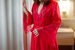A blurred image of a lady in her nightgown, unveiling the curtains to witness the morning sunlight.