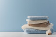 Stack of delicate colored cotton towels with cotton buds on  blue background
