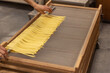 Fresh pasta drying on wooden rack