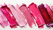 Smudged lipstick ranging from vibrant pink to deep berry shades displayed in a creative pattern on a clean white surface