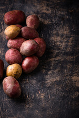 Wall Mural - Raw uncooked potato on dark table