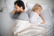 Unhappy sad couple, family, bearded man, woman, husband, wife lay in bed, turned away back to back. Unlove crisis, sexual problem issues, relationship conflict, divorce - concept image