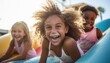 Group of young girls joyfully riding down a water slide at a carnival