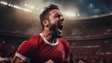 Fototapeta Sport - Football player screams with joy in the stadium. Happy soccer player celebrate a victory on a professional football stadium