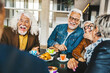 Happy senior people having breakfast sitting at cafe bar - Group of older friends having lunch at restaurant table - Food and beverage life style concept