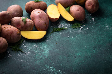 Wall Mural - Raw uncooked potato on green table