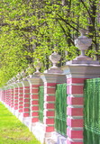 Fototapeta Las - The ancient fence of the park with stone flowerpots