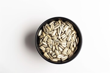 Canvas Print - Sunflower seeds in black cup on white background seen from above