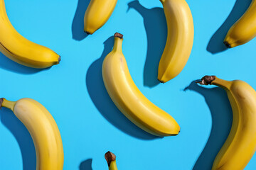 Wall Mural - Fresh ripe bananas bunch on blue background with shadows and soft lighting