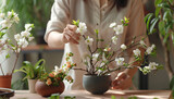 Fototapeta Desenie - Woman making ikebana at table in room, closeup