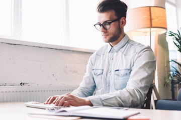 Poster - Serious male software developer keyboarding program code on modern computer sitting at desktop, caucasian skilled man working with technology connected to wireless internet while typing email
