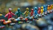 © Rattanathip - A chain with people holding hands on it. The people are of different colors and sizes. The chain is made of metal and is hanging from a rock. Concept of unity and togetherness