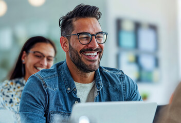 Happy man at work in a modern office, working with team of young professionals at computer desk laptops, corporate casual job