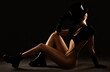 Slender woman in sexy lingerie wearing a black hat and respirator on a dark background.