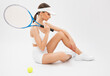 A beautiful attractive girl in white shorts and a top plays tennis. The concept of sports and healthy lifestyle.