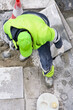 contruction workers  laying  concrete floor tiles in layers on sidewalk in  city street