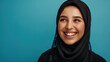 © reddish - A positive Muslim woman wearing a traditional headscarf smiles happily at the camera