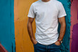 Young man wearing bella canvas white shirt mockup, at colorful background. Design tshirt template, print presentation mock-up.