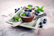 Traditional American oatmeal muffin with blueberries and walnuts served as close-up a wooden baking tray