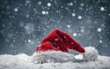 Red Santa hat on snowy backdrop with falling snowflakes.