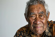 © KirKam - Elderly Pacific Islander man with a deeply lined face and bright eyes in a patterned shirt.