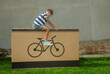Happy teenager sitting on big present box with bike drawings