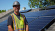 Portrait of electrician in safety helmet and uniform on background field of photovoltaic solar panels