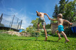 Two playful boys engage in water play at home's grassy backyard