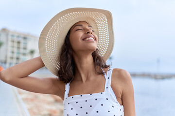 Canvas Print - Young african american woman smiling confident wearing summer hat at seaside