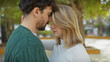 © Krakenimages.com - Intimate couple embracing in a tranquil outdoor park, portraying love and a deep connection between a young man and woman.
