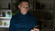 © Krakenimages.com - A young hispanic man in casual wear focused on his smartphone in a modern office environment.