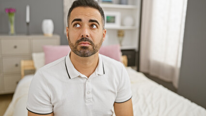 Sticker - Pensive hispanic man with beard in a modern bedroom interior contemplating.