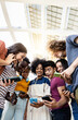 © Xavier Lorenzo - Vertical shot of group of multiracial people using cellphone outdoors. Happy young friends laughing while sharing content on social media network on smartphone. Millennial students holding mobiles