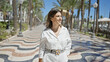 © Krakenimages.com - Young beautiful hispanic woman walking smiling at city promenade