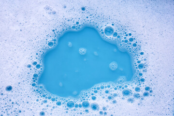 Wall Mural - Detergent foam bubble on water. Blue background, Soap sud