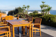 Outdoor table and chairs for tourists to relax outside in a landscaped garden with an ocean view in a restaurant of a hotel or resort. Vacation vibe for a seaside holiday, seatings in a cafe.