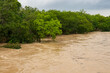 The Lampasas River rushes and roars through the Texas Hill Country, leaving a trail of flood damage in its wake across the countryside. Spring rains a view from a bridge.