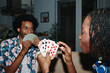 Young Black couple playing cards at home in the evening