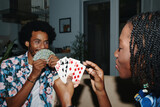 Fototapeta  - Young Black couple playing cards at home in the evening