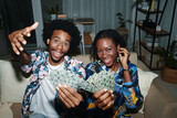 Fototapeta  - Joyful young Black couple posing with playing cards at home