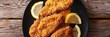 breaded chicken cutlets on black plate with lemon slices, generative AI